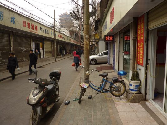 Xe máy điện và xe đạp điện đang sạc bằng dây điện kéo ra vỉa hè, cách sạc xe điện không an toàn